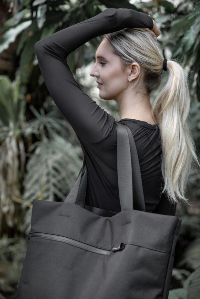 Woman carrying the large black VIK tote over her shoulder.